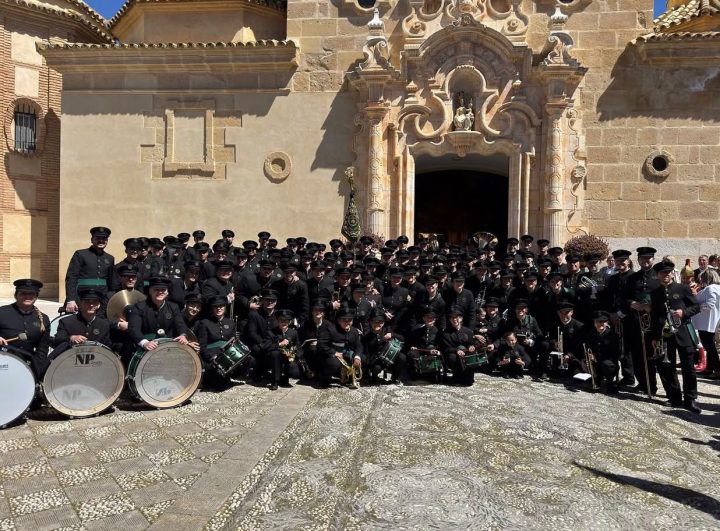 La Agrupación Musical Vera+Cruz al completo ante la portada de la iglesia