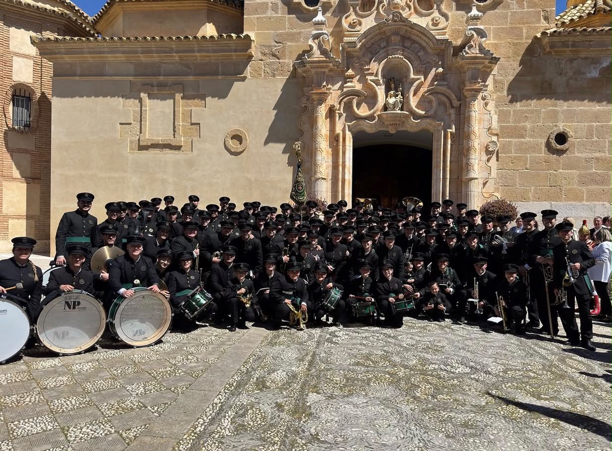 La Agrupación Musical Vera+Cruz al completo ante la portada de la iglesia