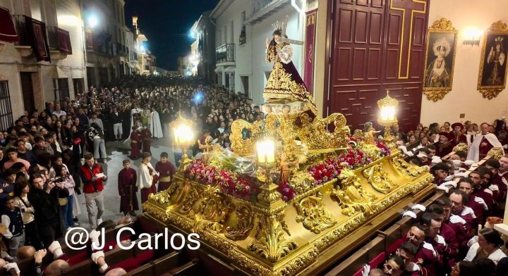 El trono del Dulce Nombre de Jesús entrando en la Casa-Cofradía, de noche, entre el público y sus portadores de grana