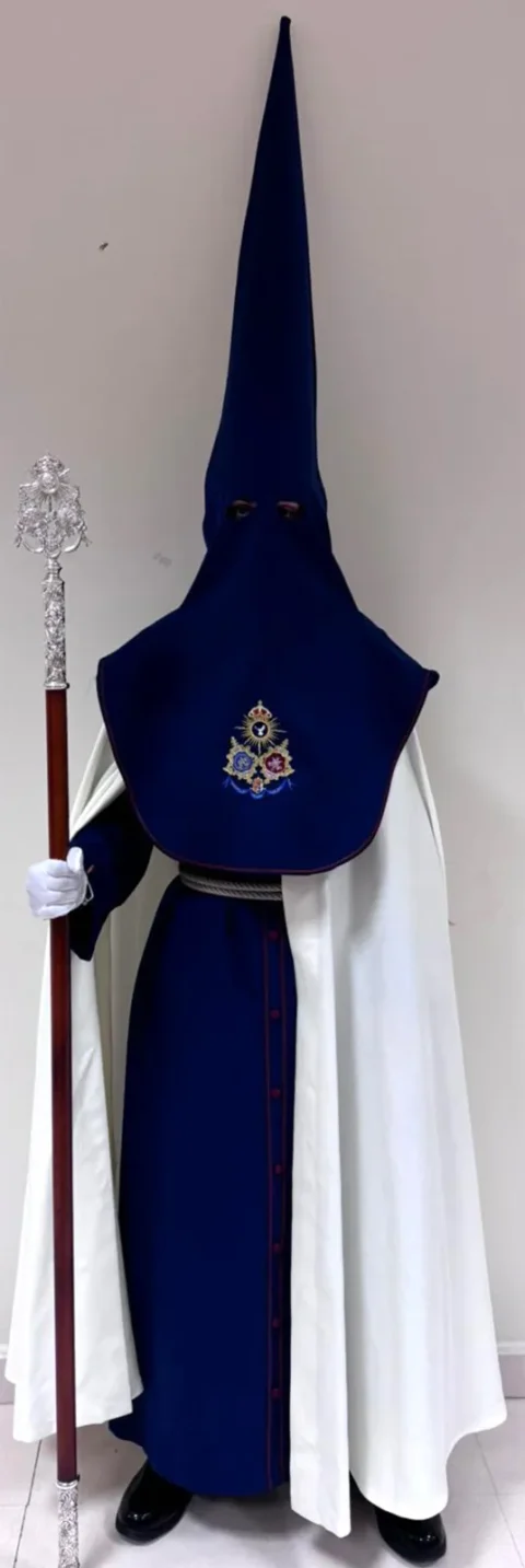 Hábito del Cristo Ultrajado con capa blanco roto sobre la túnica azul y vara de plata.
