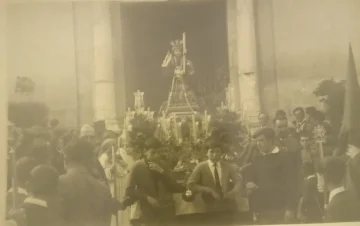 The Niño Chiquito on its trono leaving the church, among the crowd, in a historic photograph.