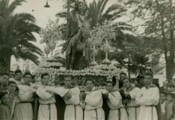 The Pollinica trono carried by its bearers, dressed in white, in a historic photograph.