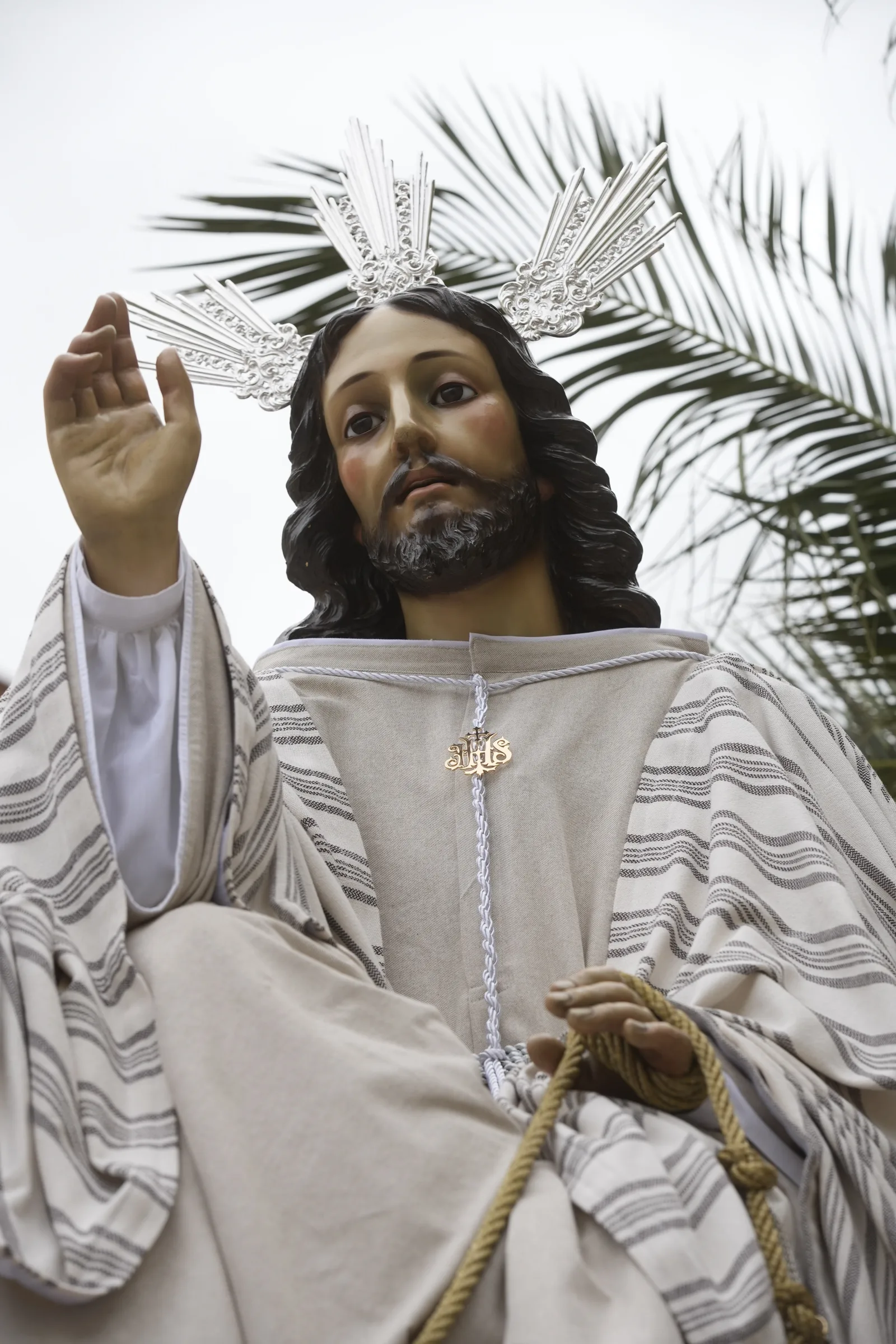 Jesús en su Entrada Triunfal, vestido de blanco entre palmas