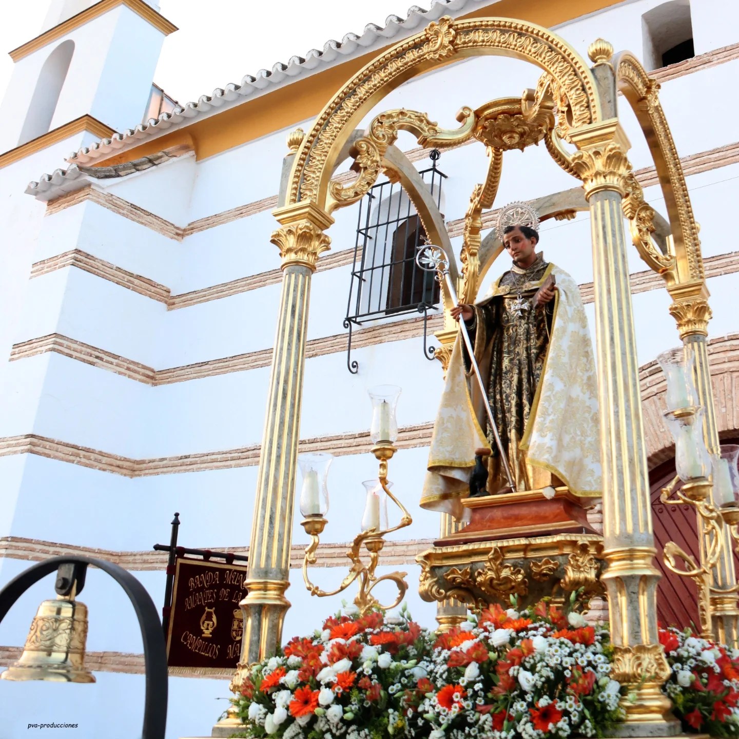San Benito Abad en su trono dorado, con flores, ante la ermita
