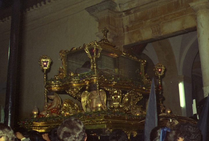 Fotografía antigua del trono del Santo Entierro, con la urna dorada, ángeles y faroles