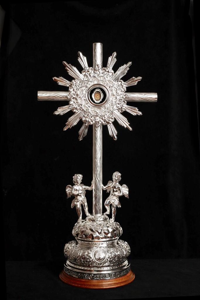 Relicario de plata del Santo Lignum Crucis, una cruz rodeada de rayos sostenida por dos ángeles