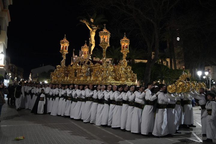 El trono del Santísimo Cristo de la Vera+Cruz de noche, a hombros de sus portadores de túnica blanca y fajín verde