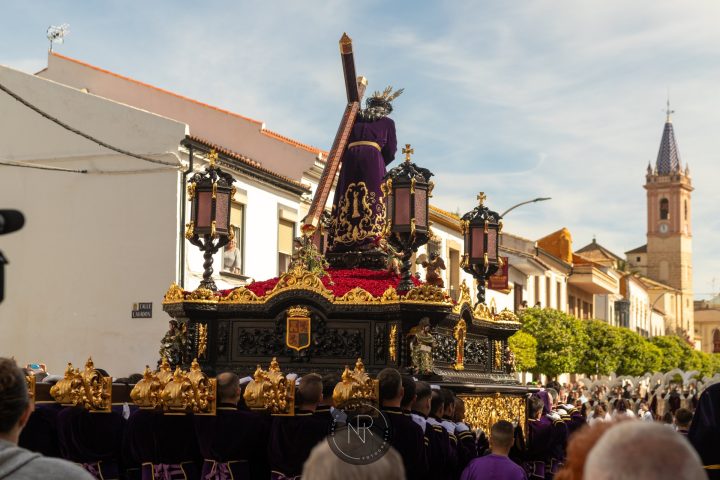 El trono de Jesús Nazareno por las calles de Campillos, con la torre parroquial al fondo