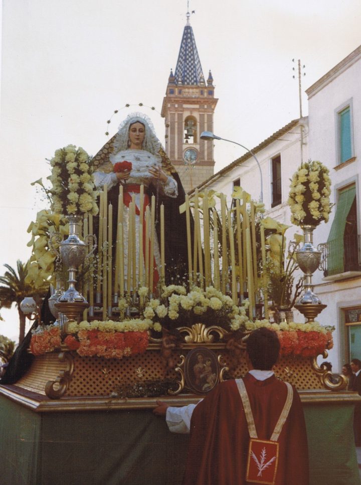 María Santísima de Gracia y Esperanza en su trono ante la torre parroquial, en una fotografía antigua