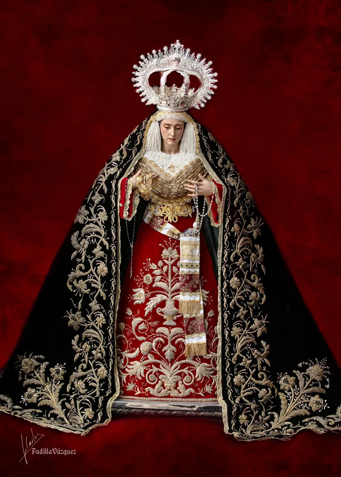 María Santísima del Socorro wearing a crimson skirt and an embroidered mantle